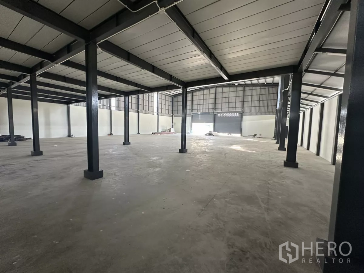 Warehouse for rent in Prawet, Bangkok - Wide undercroft area beneath the mezzanine with columns and concrete floor.
