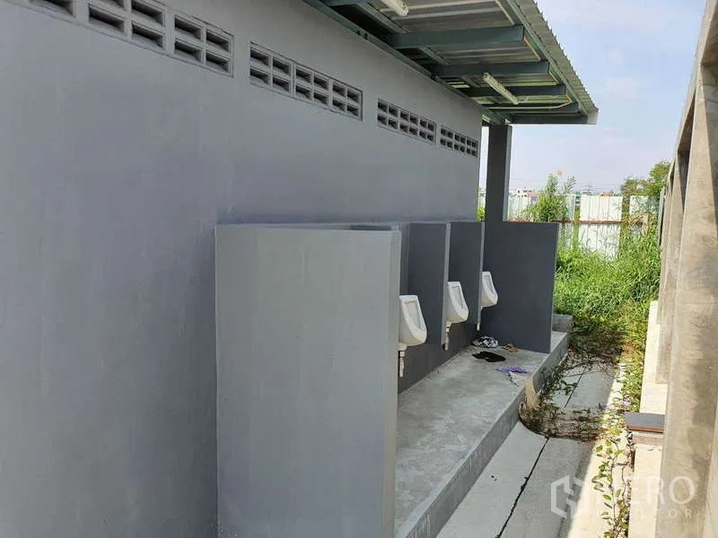 工厂 出租在Mueang Samut Prakan, Samut Prakan - 室外卫生间建筑，雨棚下的立式小便器，位于厂区一侧。