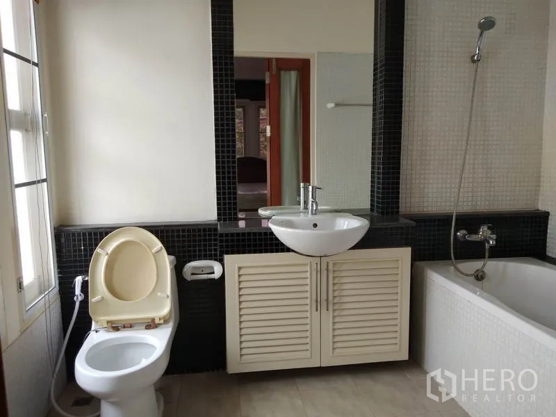 Detached House for rent in Watthana, Bangkok - Bathroom with bathtub and handheld shower, vanity with sink and toilet.