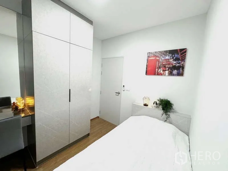 Townhouse for rent in Bang Phli, Samut Prakan - Guest bedroom with large wardrobe and wall art above the bed.