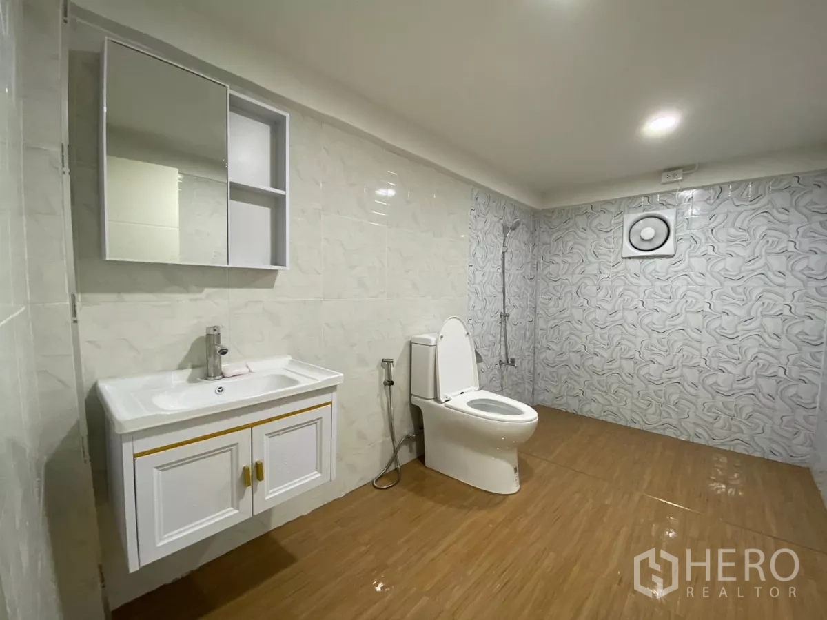 独立式住宅 出租在Bang Na, Bangkok - 现代卫生间，带浴室柜、坐便、手持花洒和纹理墙砖。