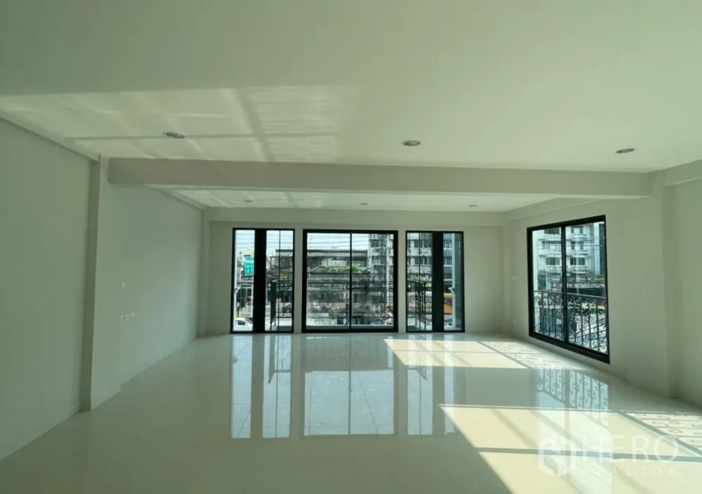 Home Office for rent in Suan Luang, Bangkok - Corner room with wide sliding glass doors, balcony railings and abundant daylight.