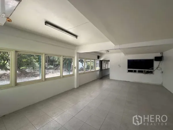 Warehouse for rent in Pak Kret, Nonthaburi - Bright office room with tiled floors and rows of windows overlooking greenery.