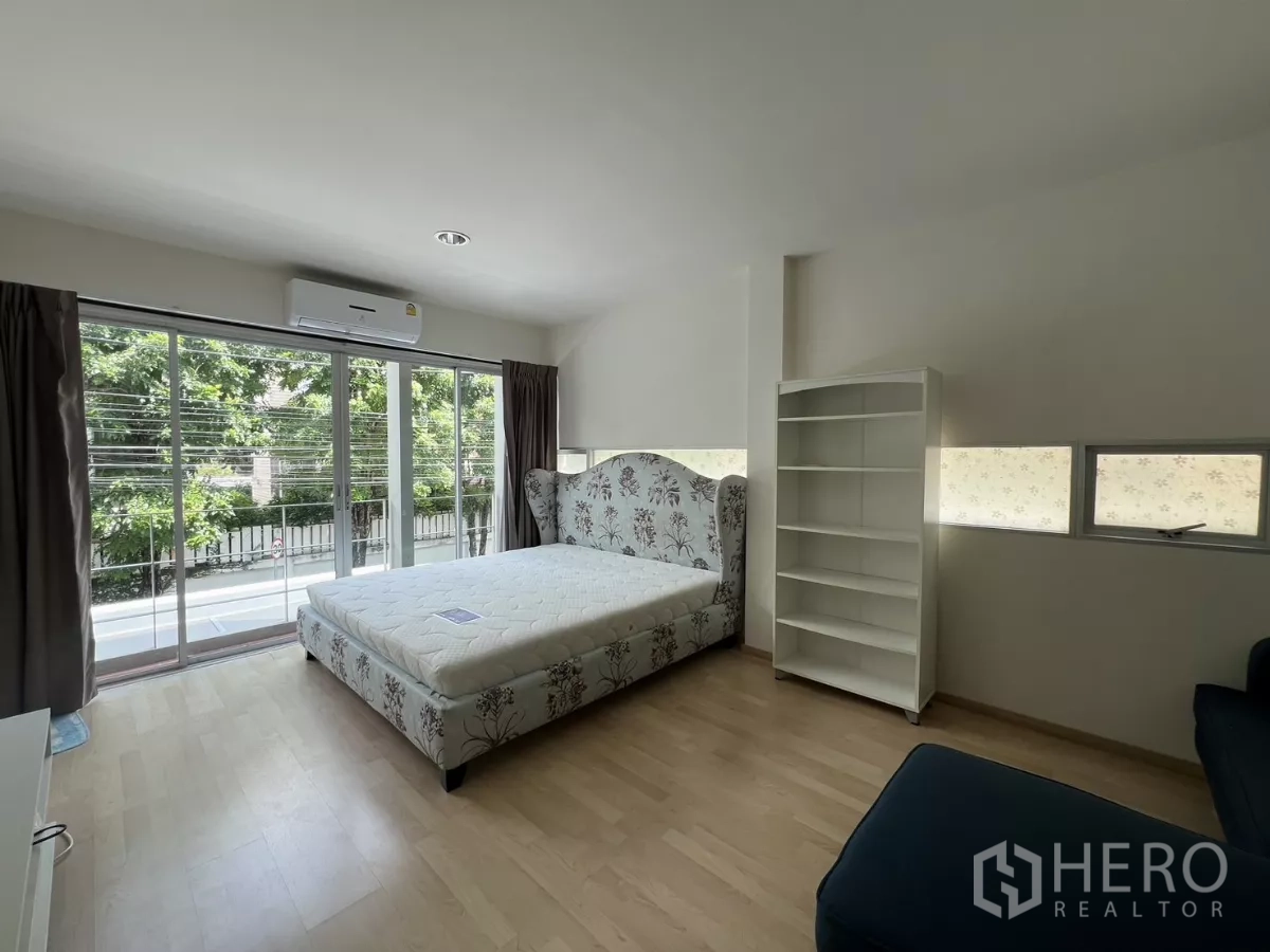 Townhouse for rent in Suan Luang, Bangkok - Bedroom view showing bed and blue sofa seating area.