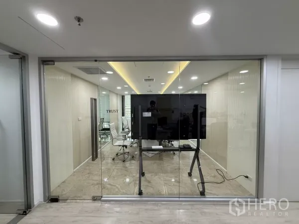 Office Space for rent in Din Daeng, Bangkok - Glass‑walled boardroom featuring white executive chairs and a large presentation screen in a modern corridor setting.