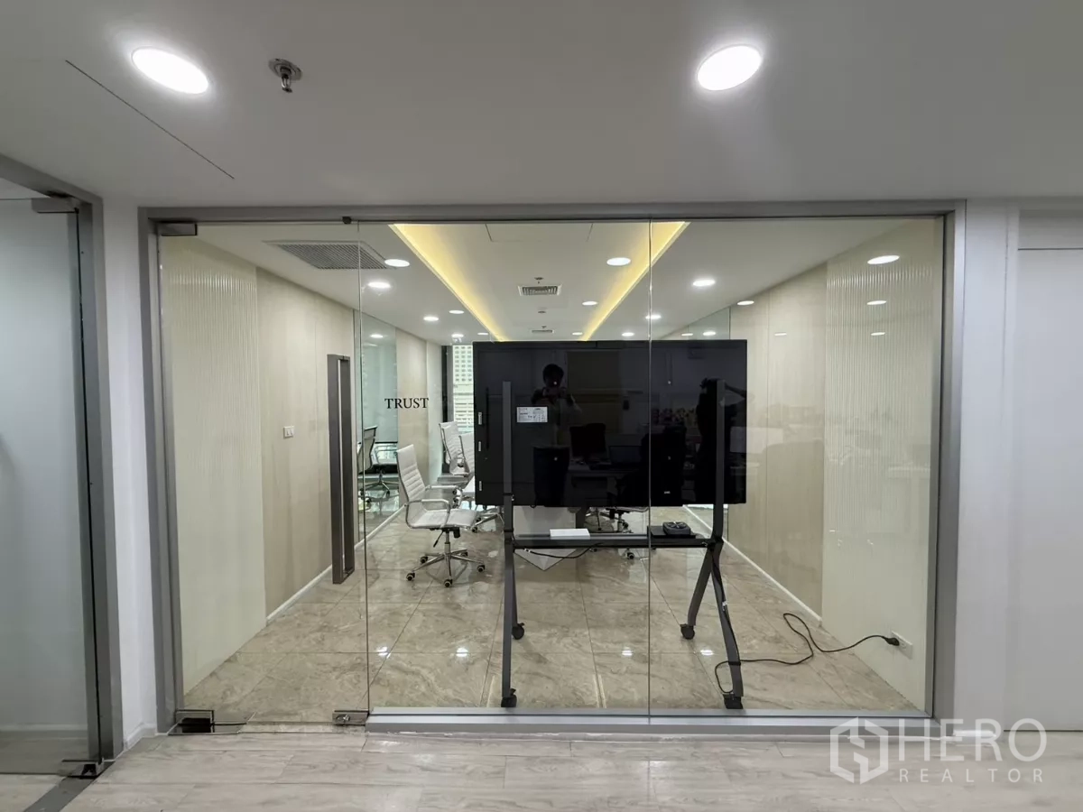 Office Space for rent in Din Daeng, Bangkok - Glass‑walled boardroom featuring white executive chairs and a large presentation screen in a modern corridor setting.