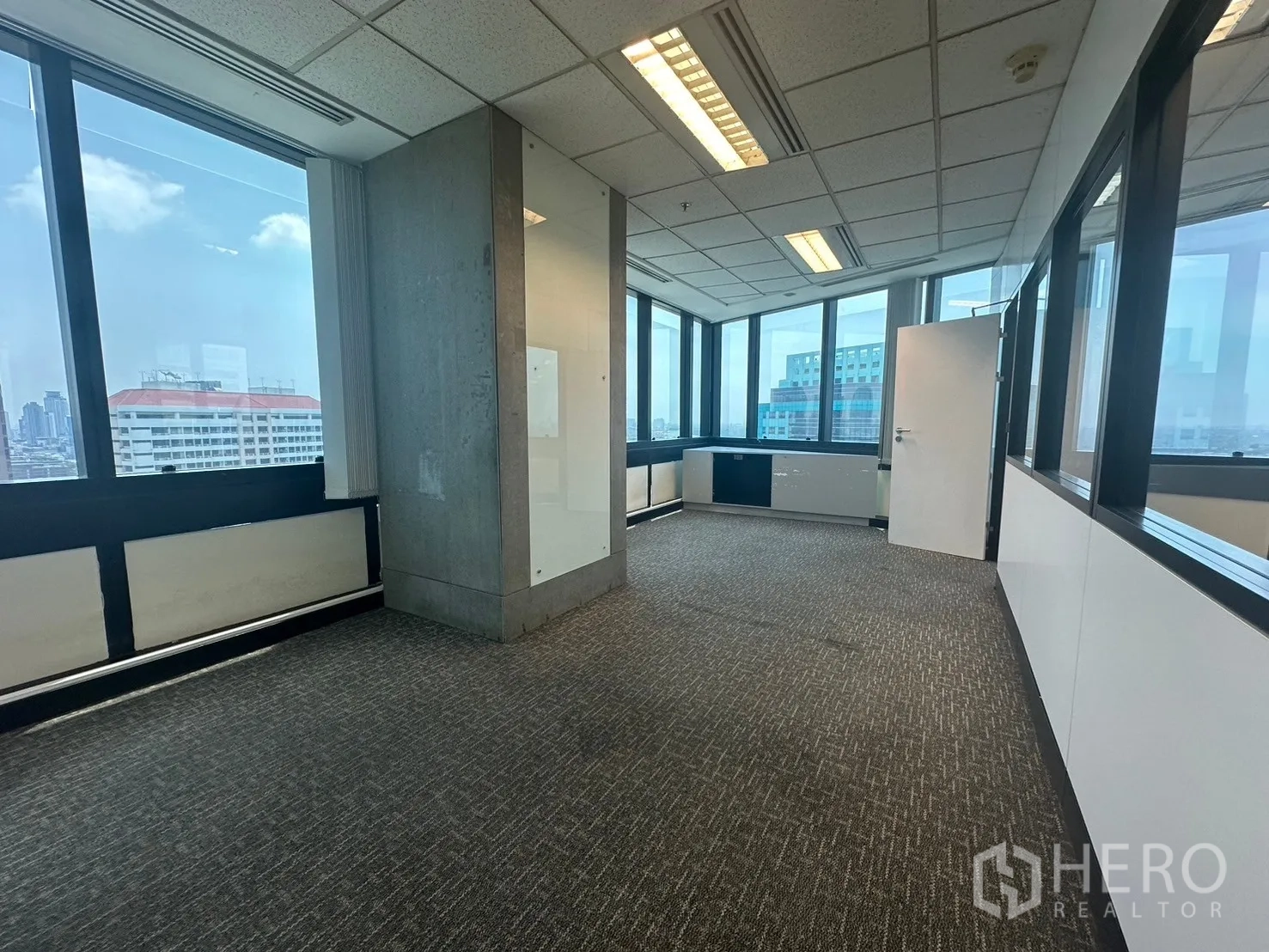 Office Space for rent in Khlong Toei, Bangkok - Corner room with large windows offering a Bangkok skyline view.