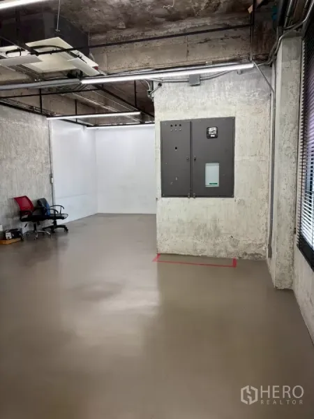 办公空间 出租在Watthana, Bangkok - 宽敞工作区，水泥墙面、吊顶管线与线性灯，可见电箱设备。