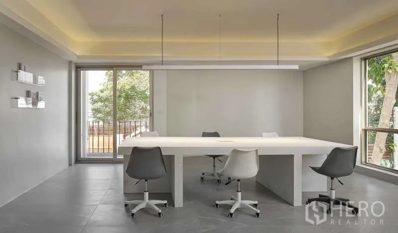 Home Office for sale in Chatuchak, Bangkok - Bright workspace with long white table, swivel chairs and balcony access.