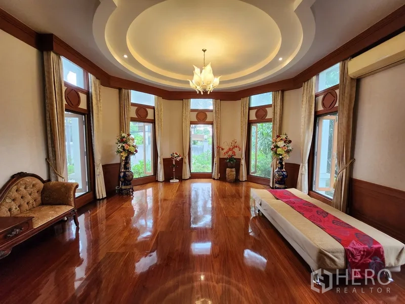 Detached House for rent in Prawet, Bangkok - Large bay‑window reception room with circular ceiling detail and glossy timber flooring.