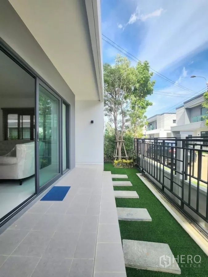 Detached House for rent in Bang Phli, Samut Prakan - Side terrace with sliding glass doors, small lawn and stepping stones.