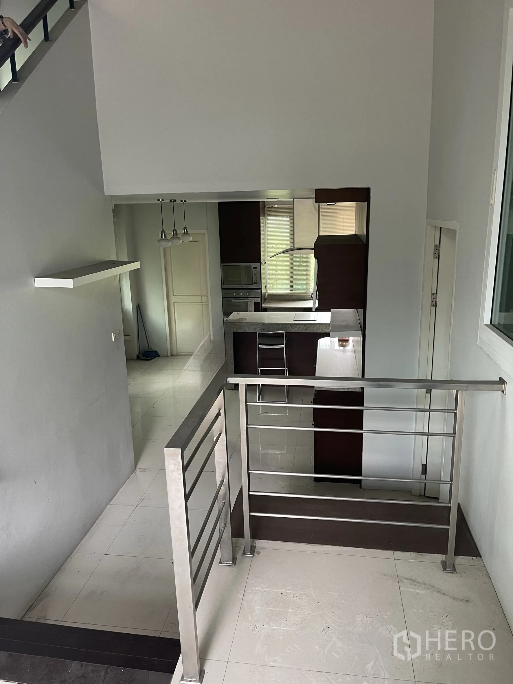 Home Office for rent in Wang Thonglang, Bangkok - Mezzanine landing overlooking the kitchen with stainless railings and tiled floors.
