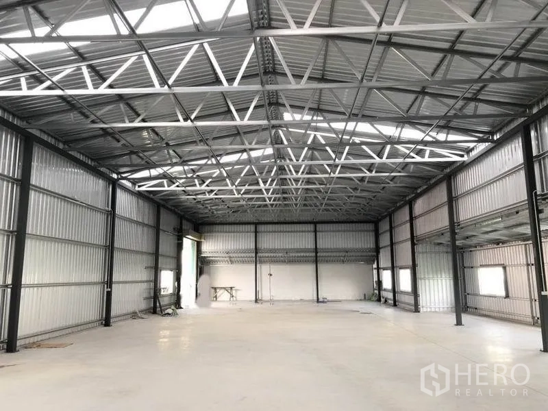 Warehouse for rent in Don Mueang, Bangkok - Bright, high-ceiling warehouse interior with steel truss roof and polished concrete floor.