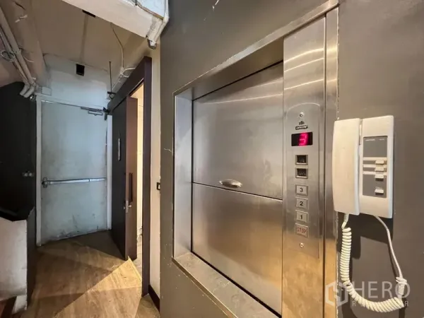 Shophouse for rent - Service corridor featuring a stainless-steel dumbwaiter lift and wall-mounted phone.