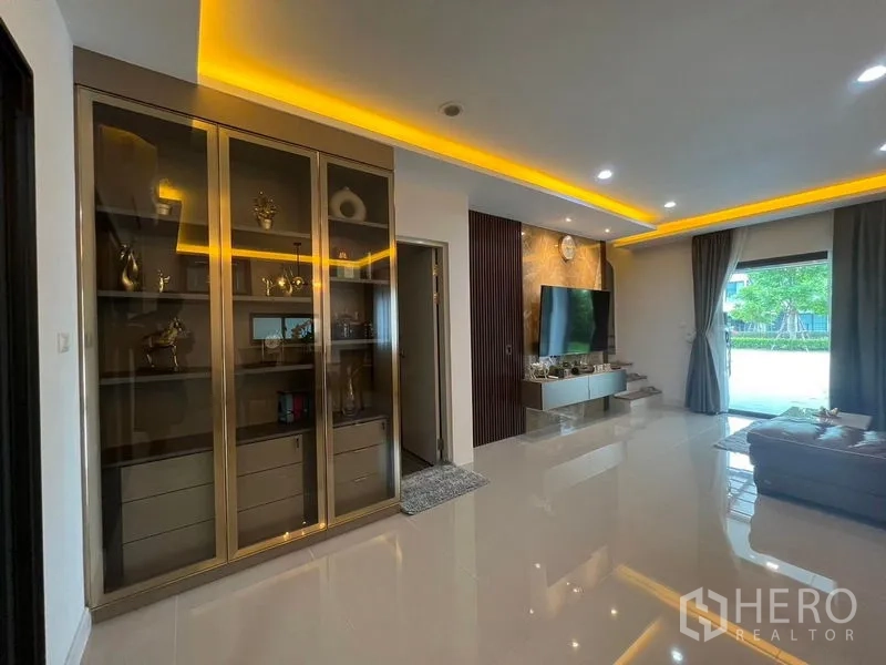 Townhouse for rent - Open living area showing built-in glass display cabinet and marble TV wall with recessed lights.
