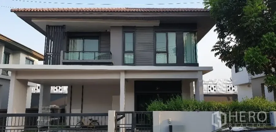 Detached House for rent or sale in Lam Luk Ka, Pathum Thani - Two-storey modern detached house facade with balcony, carport and front garden.