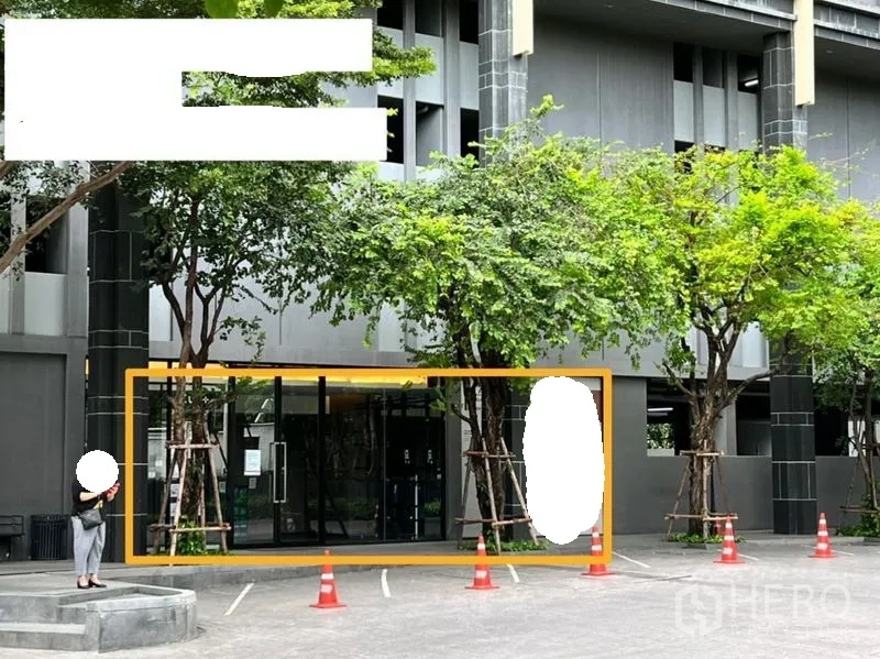 Retail Space for rent in Watthana, Bangkok - Ground-floor retail frontage with full-height glass facade, shade trees, and short-stay parking at a modern Bangkok building.