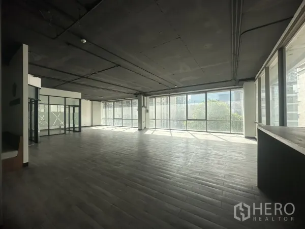 Office Space for rent in Khlong Toei, Bangkok - Panoramic office space with wall‑to‑wall windows overlooking greenery and nearby buildings.