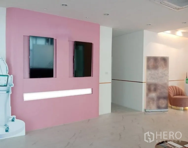 Retail Space for rent in Watthana, Bangkok - Pink display wall with recessed screens and accent lighting in the showroom.