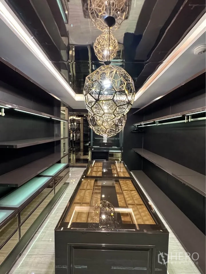 Condominium for rent or sale in Khlong Toei, Bangkok - Long wardrobe gallery with mirrored ceiling, shelving and statement pendants.