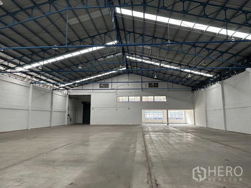 Factory for rent in Bang Phli, Samut Prakan - Spacious warehouse floor with high 8m ceiling, steel roof trusses and skylights for natural light.