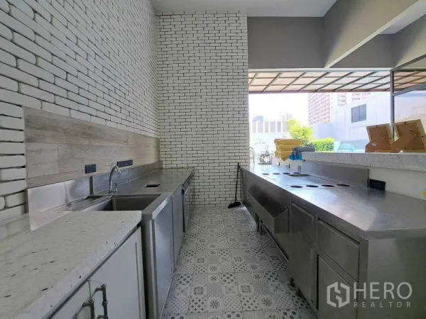 Retail Space for rent in Watthana, Bangkok - Commercial prep kitchen with stainless counters, white brick walls and patterned tile flooring.