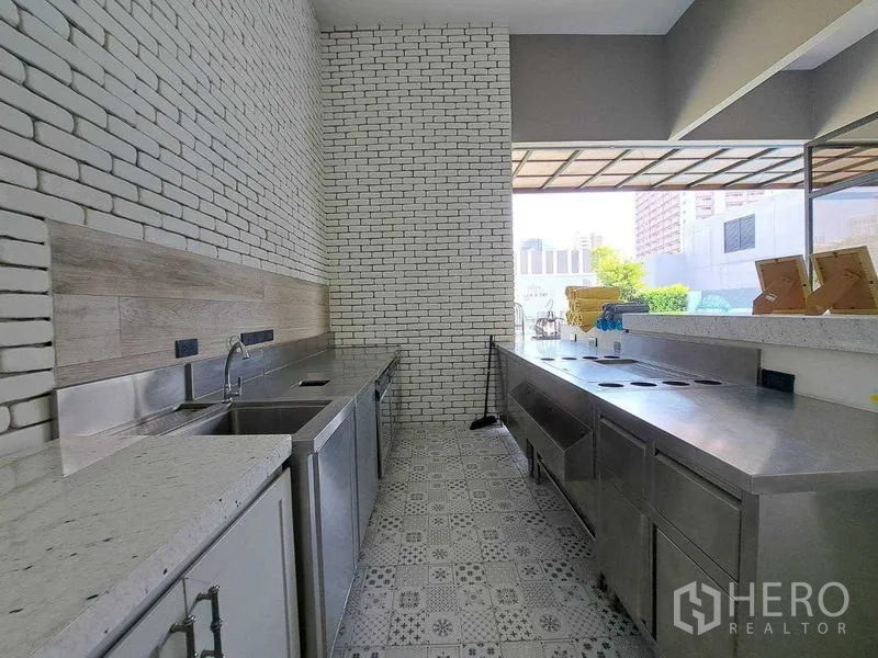 Retail Space for rent in Watthana, Bangkok - Commercial prep kitchen with stainless counters, white brick walls and patterned tile flooring.