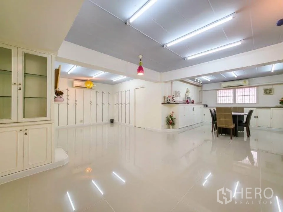 Office Space for rent in Khlong Toei, Bangkok - Open showroom space with built-in display cabinets and pendant lights.