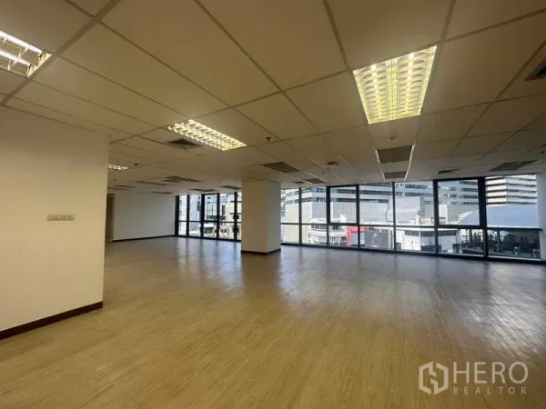 Office Space for rent in Watthana, Bangkok - Corner office area featuring floor-to-ceiling windows, fluorescent lighting, and views over the Sukhumvit skyline.