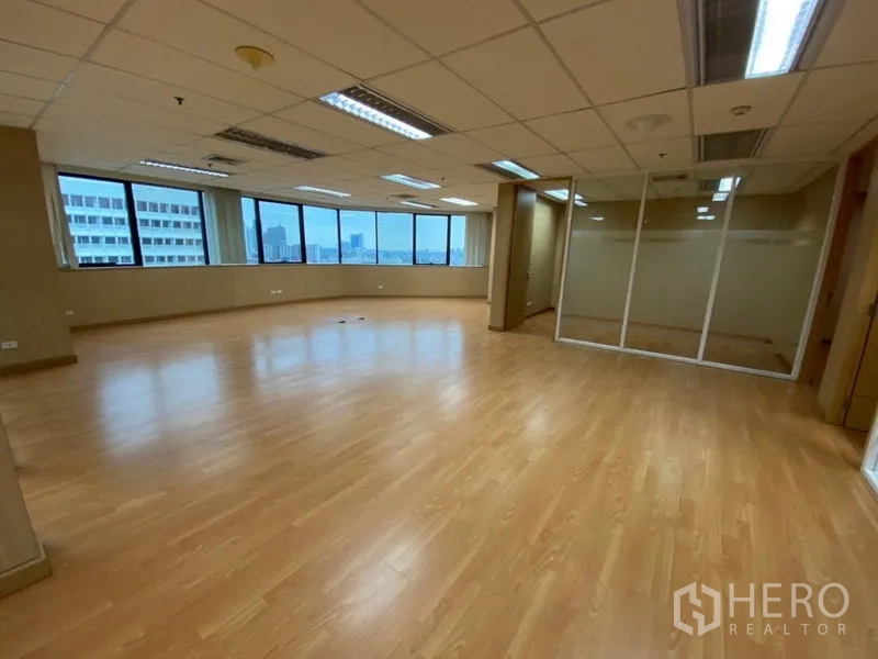 Office Space for rent in Watthana, Bangkok - Wide workspace with a curved window line, glass meeting room, and city outlook.