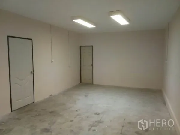 Warehouse for rent in Suan Luang, Bangkok - Large office space with two doors and bright ceiling fluorescent lighting.