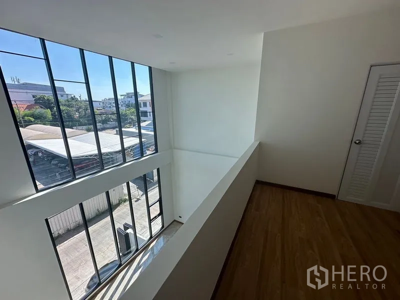 Home Office for rent in Wang Thonglang, Bangkok - View from the mezzanine down to the double-height hall and full-height glass facade.