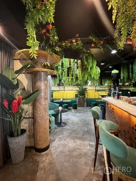 Retail Space for rent in Watthana, Bangkok - Lounge seating with green sofas, a decorative column, and foliage beside the bar.