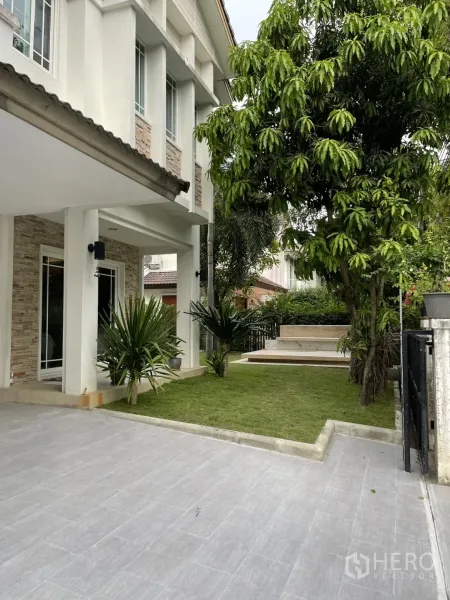 Detached House for rent in Bang Kapi, Bangkok - Tiled driveway with a small landscaped front lawn and large shade tree beside the entrance.