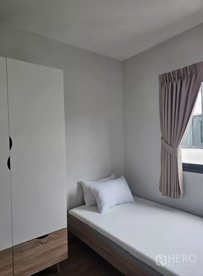 Townhouse for rent in Bang Phli, Samut Prakan - Compact third bedroom with single bed, wardrobe and curtained window.