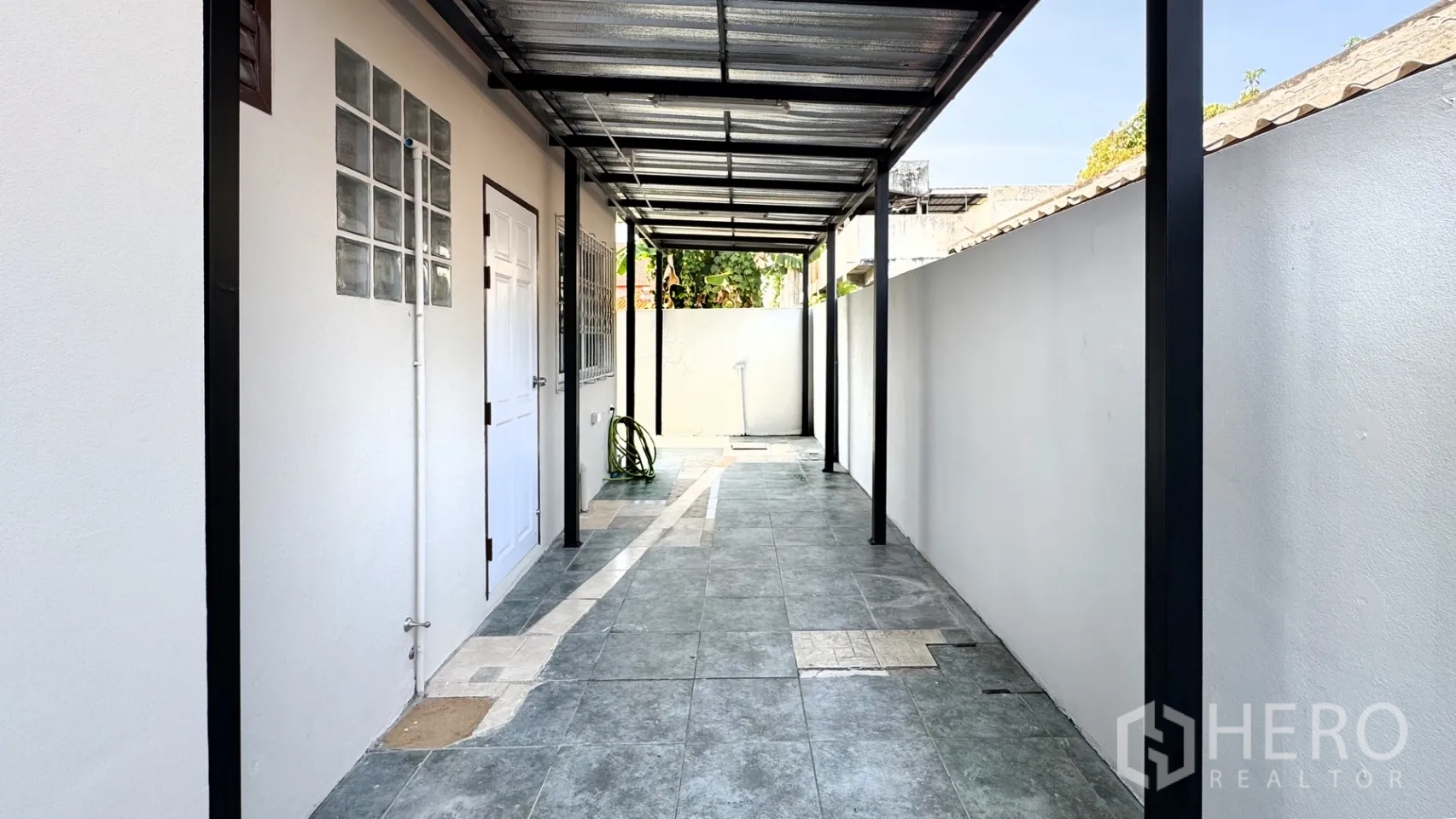 บ้านเดี่ยว for rent in Suan Luang, Bangkok - ทางเดินด้านข้างมีหลังคาตลอดแนว ปูกระเบื้อง และมีประตูเข้าพื้นที่ต่างๆ ของบ้าน