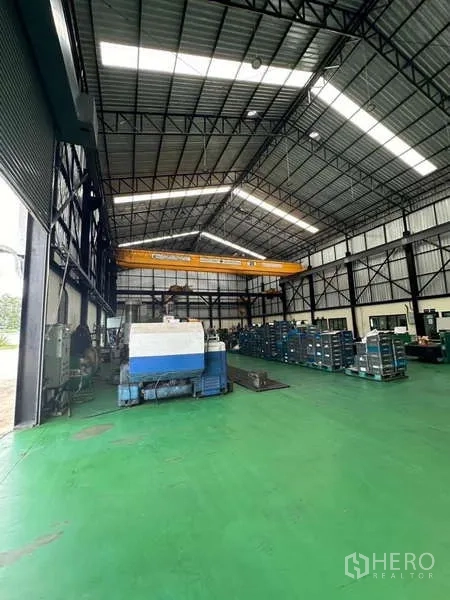 Factory for sale in Si Racha, Chon Buri - Workshop bay with roller shutter entrance, overhead crane and machines.
