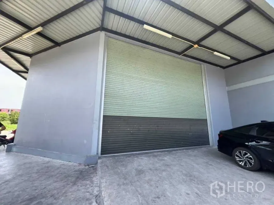 Warehouse for rent in Bang Khun Thian, Bangkok - Covered loading bay with a large roll-up shutter at the warehouse exterior.