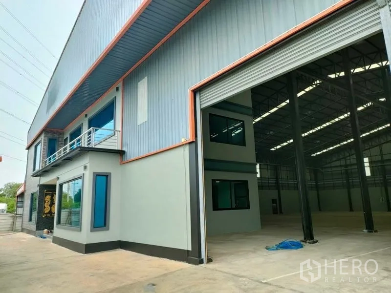 Factory for rent in Ban Phaeo, Samut Sakhon - Factory exterior with tall roller shutter revealing warehouse interior.