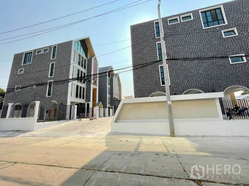 带办公室的家 出租在Bang Kapi, Bangkok - 现代封闭式园区，砖饰立面的Home Office与宽阔车道。