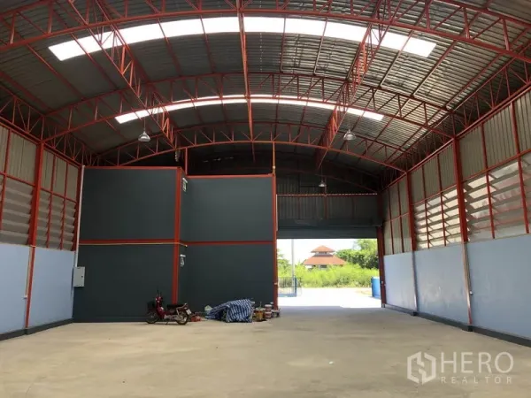 Warehouse for rent or sale in Sai Noi, Nonthaburi - Interior view toward the entrance roller shutter with clear-span floor and ventilation panels.