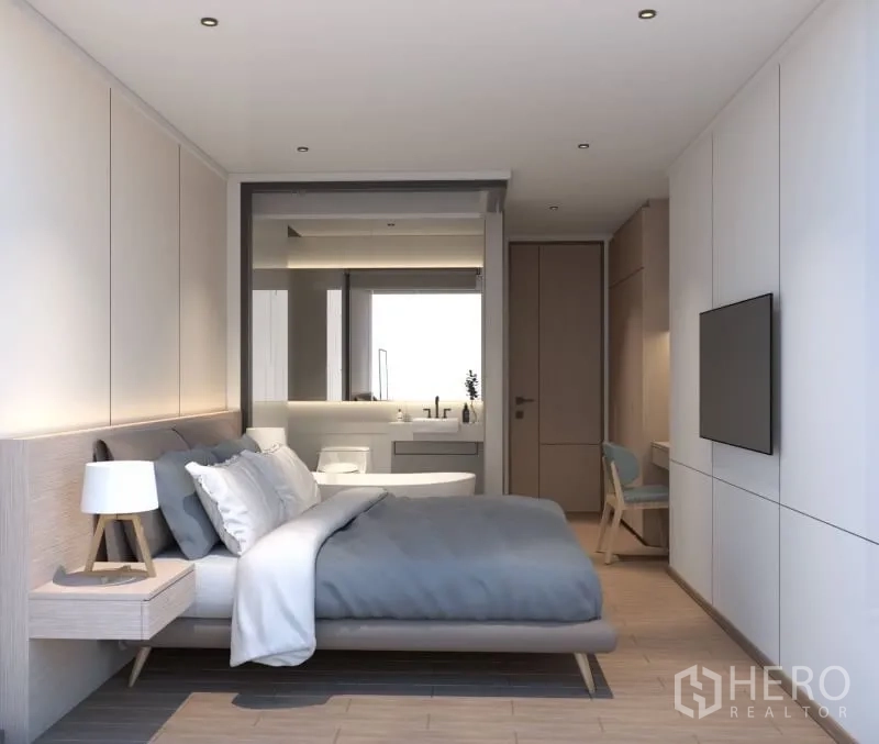 Condominium for rent or sale in Bang Rak, Bangkok - Master bedroom with built-in storage and a glass-partitioned ensuite featuring a vanity and soaking tub.