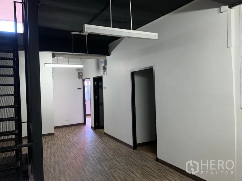 店屋 出租在Watthana, Bangkok - 长走廊连接多间房，悬挂线性灯具。