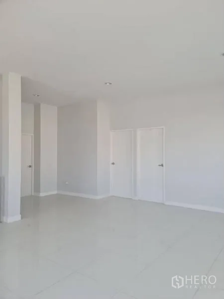 Factory for rent or sale in Lam Luk Ka, Pathum Thani - Spacious white room with two internal doors and tiled flooring.