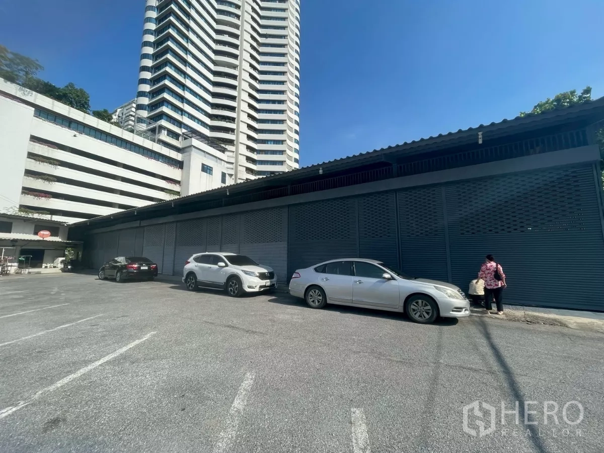 Warehouse for rent or sale in Yan Nawa, Bangkok - Long warehouse frontage with closed roller shutters and wide parking bays along the facade.