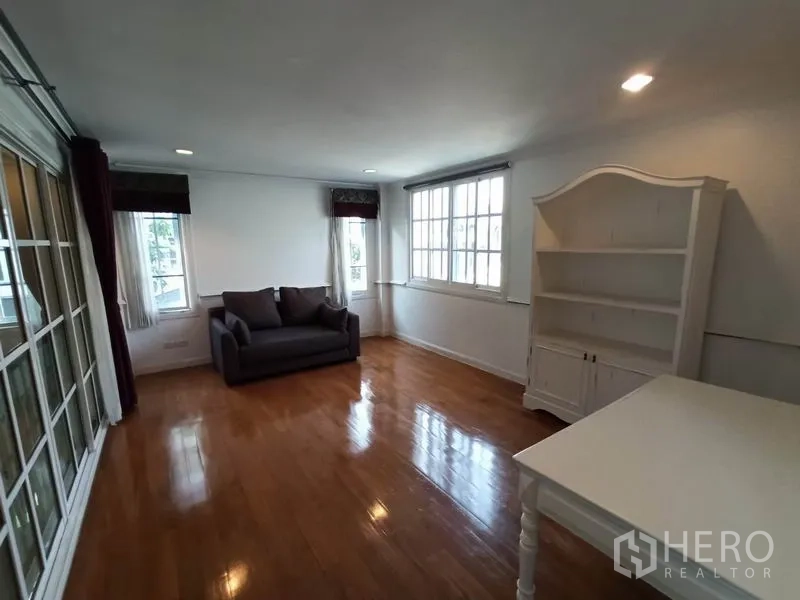 Detached House for rent in Mueang Samut Prakan, Samut Prakan - Upstairs family room or study with sofa, bookshelf and wide windows.