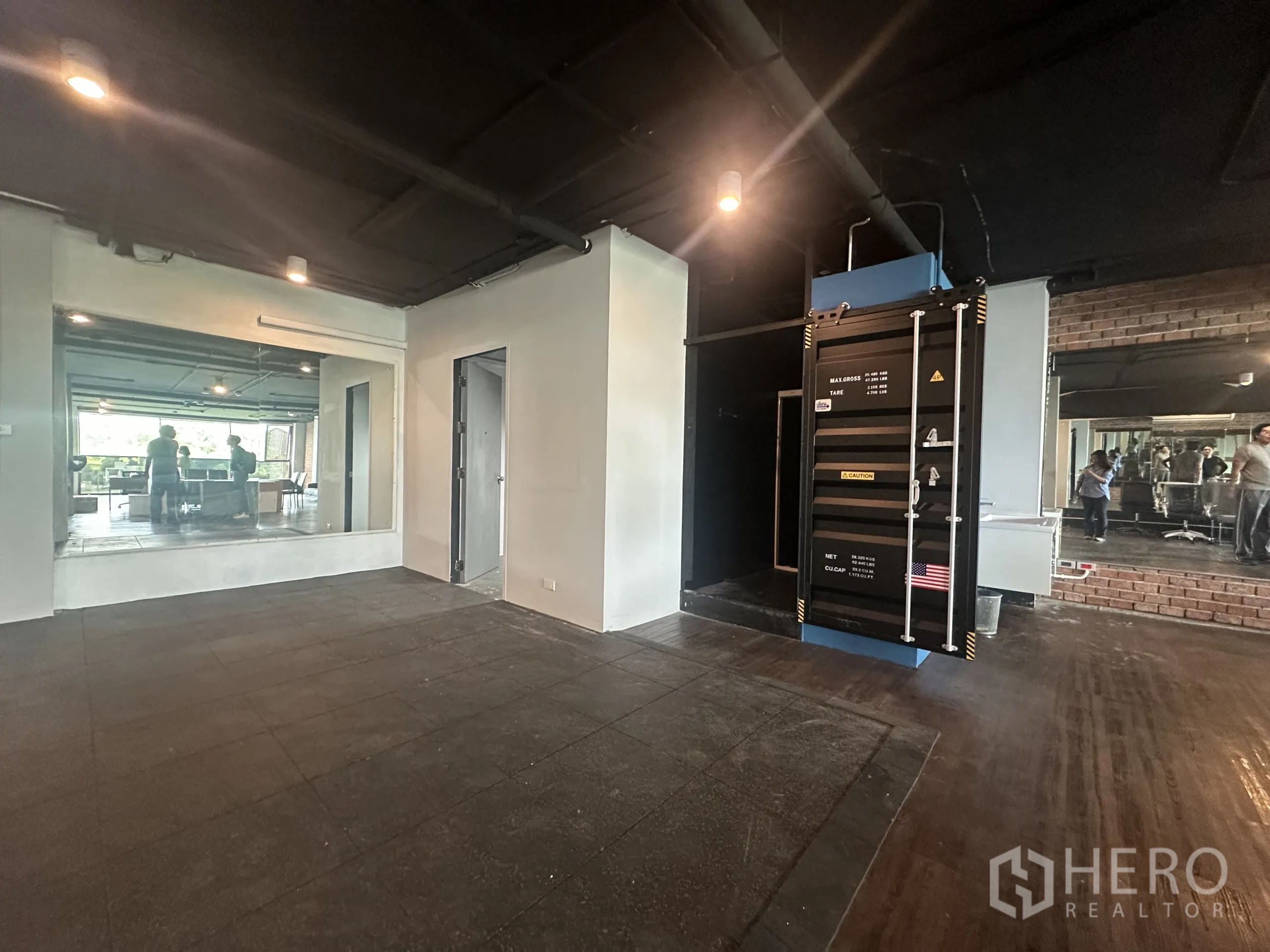 Office Space for rent in Watthana, Bangkok - Multipurpose area with rubber tiles, large mirror and a container-style server rack next to a private room.