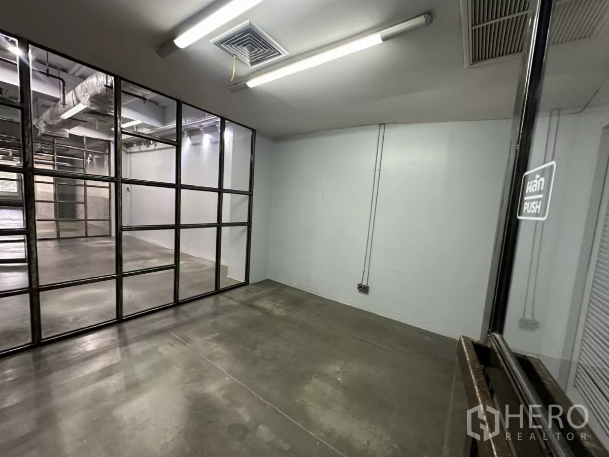 Office Space for rent - Small enclosed room with grid glass partition and fluorescent lighting.