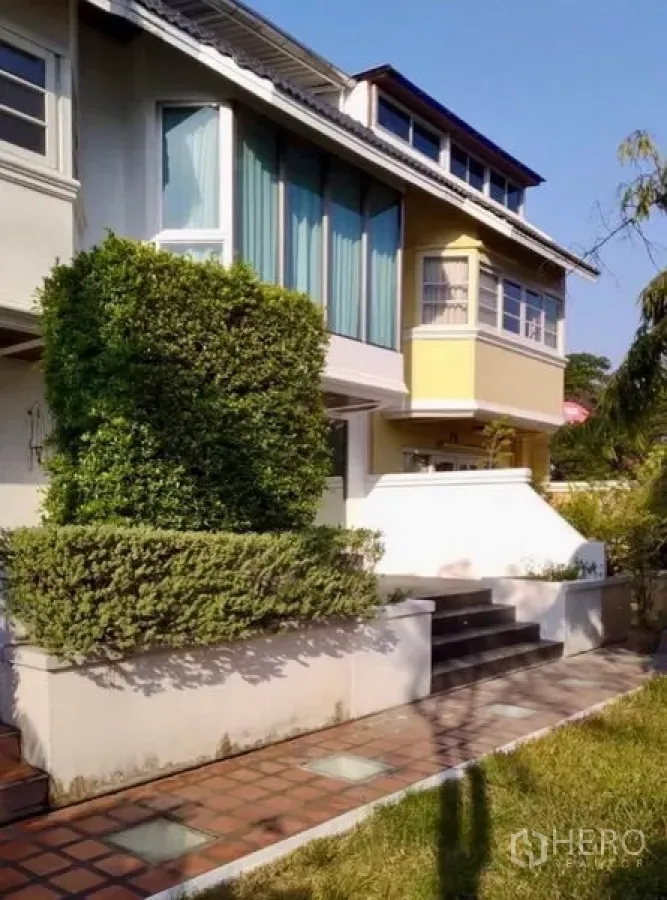 Townhouse for rent or sale in Khlong Toei, Bangkok - Modern Thonglor-area townhouse exterior with landscaped hedges and front steps.
