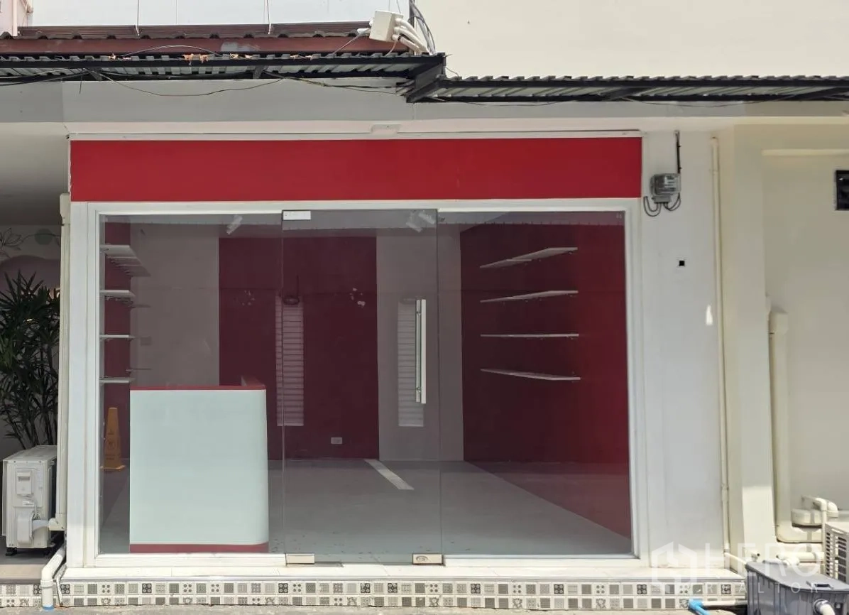 Retail Space for rent in Watthana, Bangkok - Exterior view of a small retail shop with full-height glass storefront and red trim.
